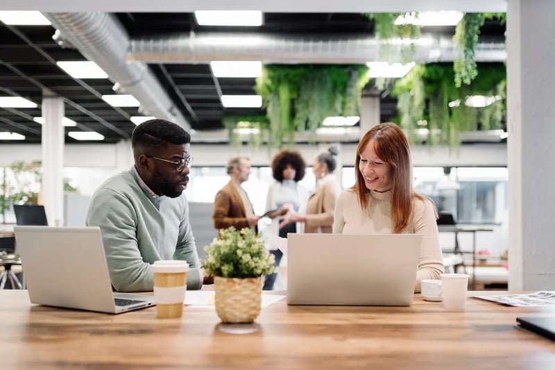 Woman-In-Her-40s-With-Male-Colleague-Talking-In-Office