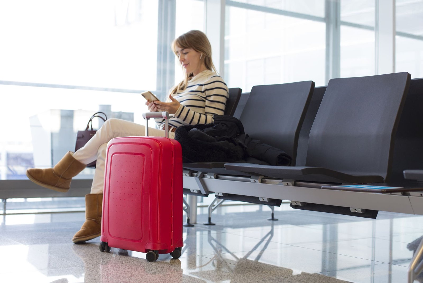 Woman-getting-ready-to-board-a-plane-while-working-from-her-phone-how-to-get-a-remote-job